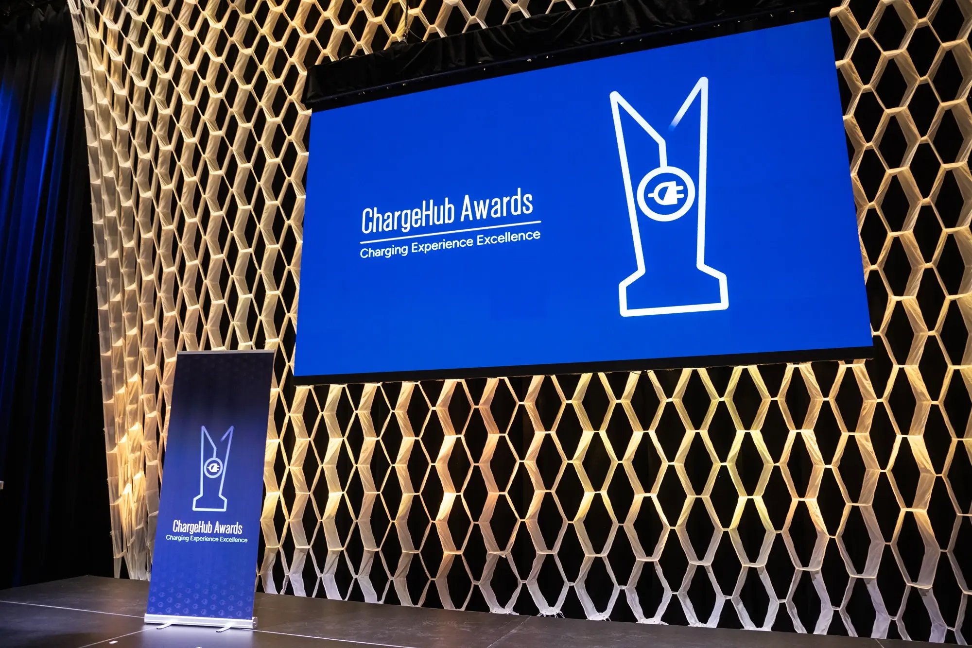 Stage display with ChargeHub Awards Charging Experience Excellence branding and event banner.