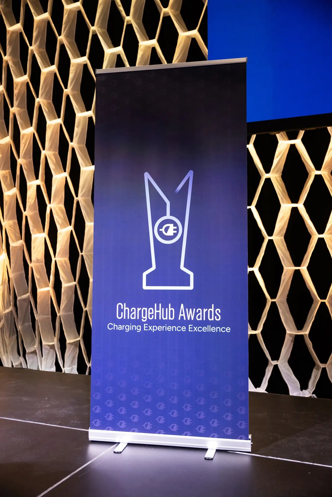 ChargeHub Awards Charging Experience Excellence banner on stage at the ceremony.