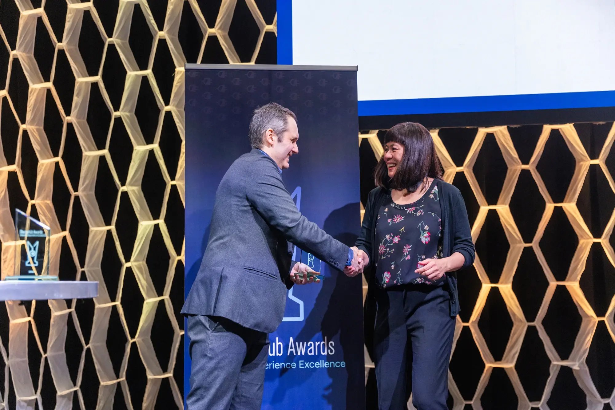Simon Ouellette shaking hands with an award recipient on stage at the ChargeHub Awards ceremony.