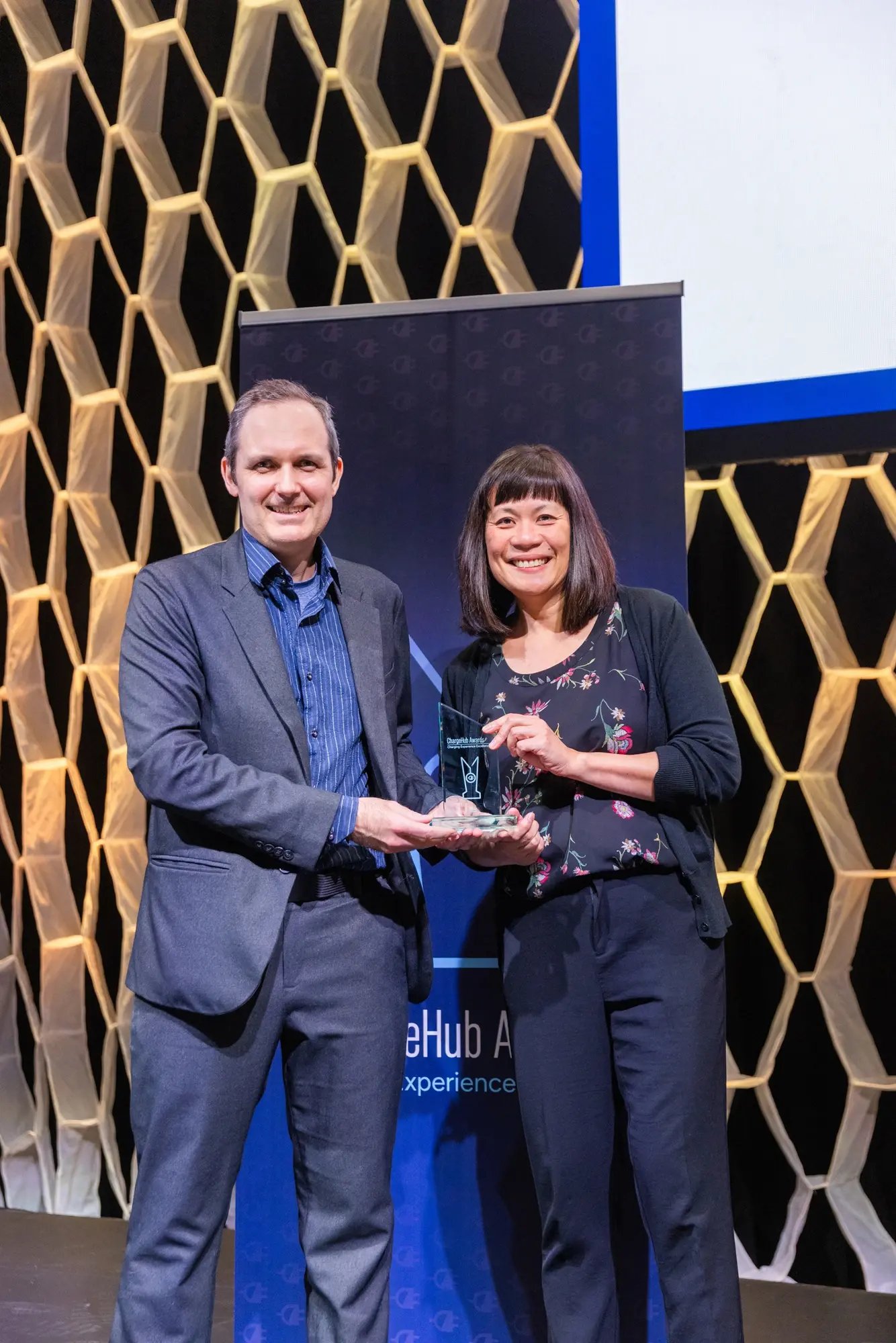 Simon Ouellette and an award recipient posing with a ChargeHub Awards trophy at the ceremony.