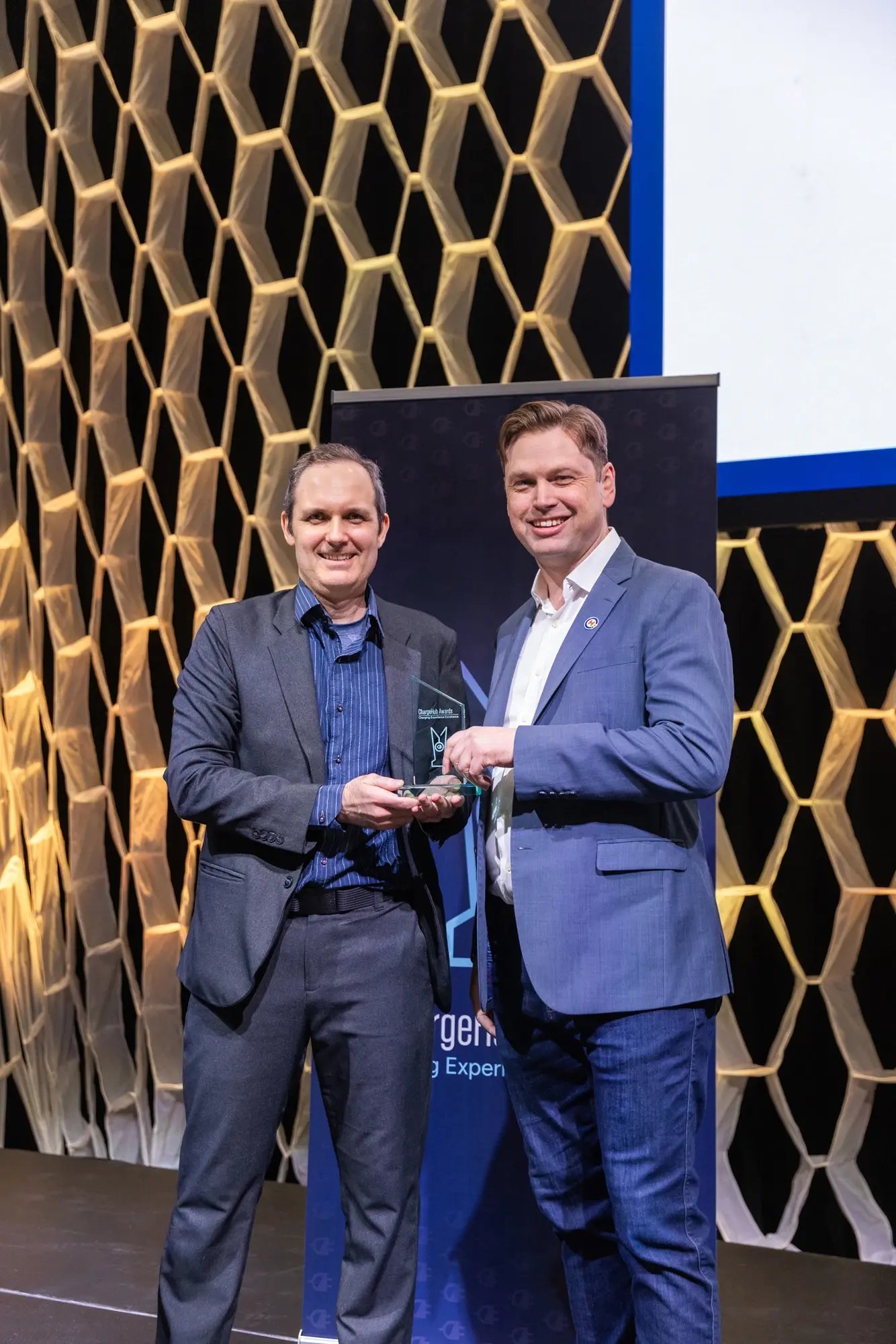 Simon Ouellette and an award recipient holding a ChargeHub Awards trophy during the ceremony.