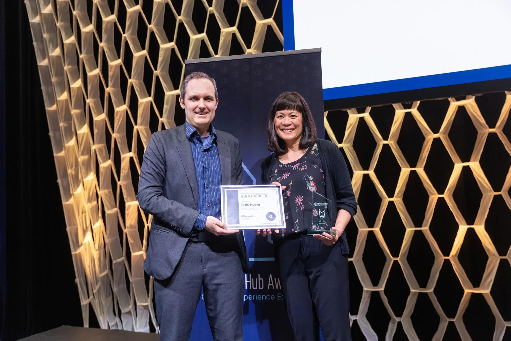 Simon Ouellette and a BC Hydro recipient holding a special recognition certificate and ChargeHub Awards trophy.