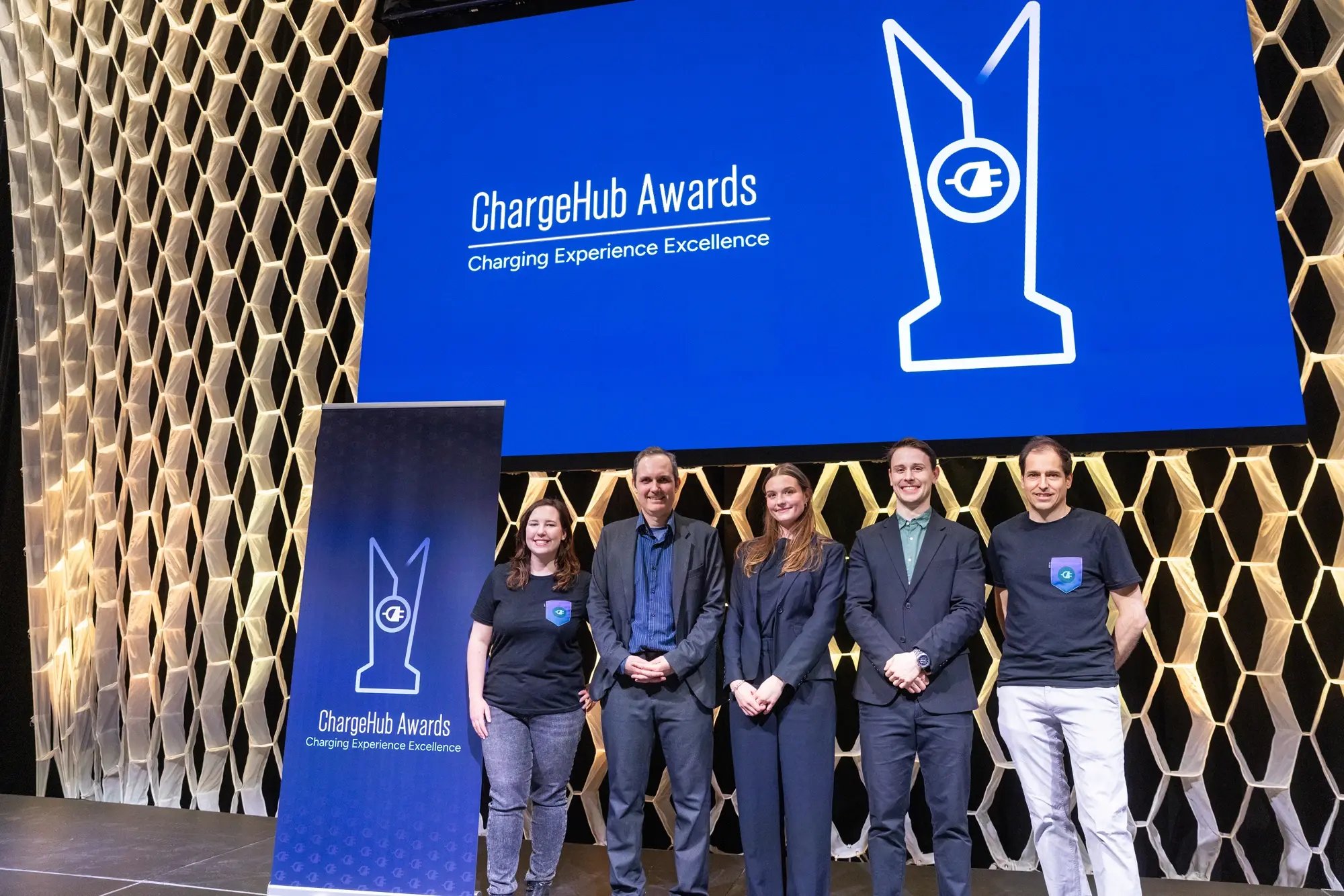 Wide group photo of Simon Ouellette and ChargeHub team members on stage beneath the ChargeHub Awards screen.