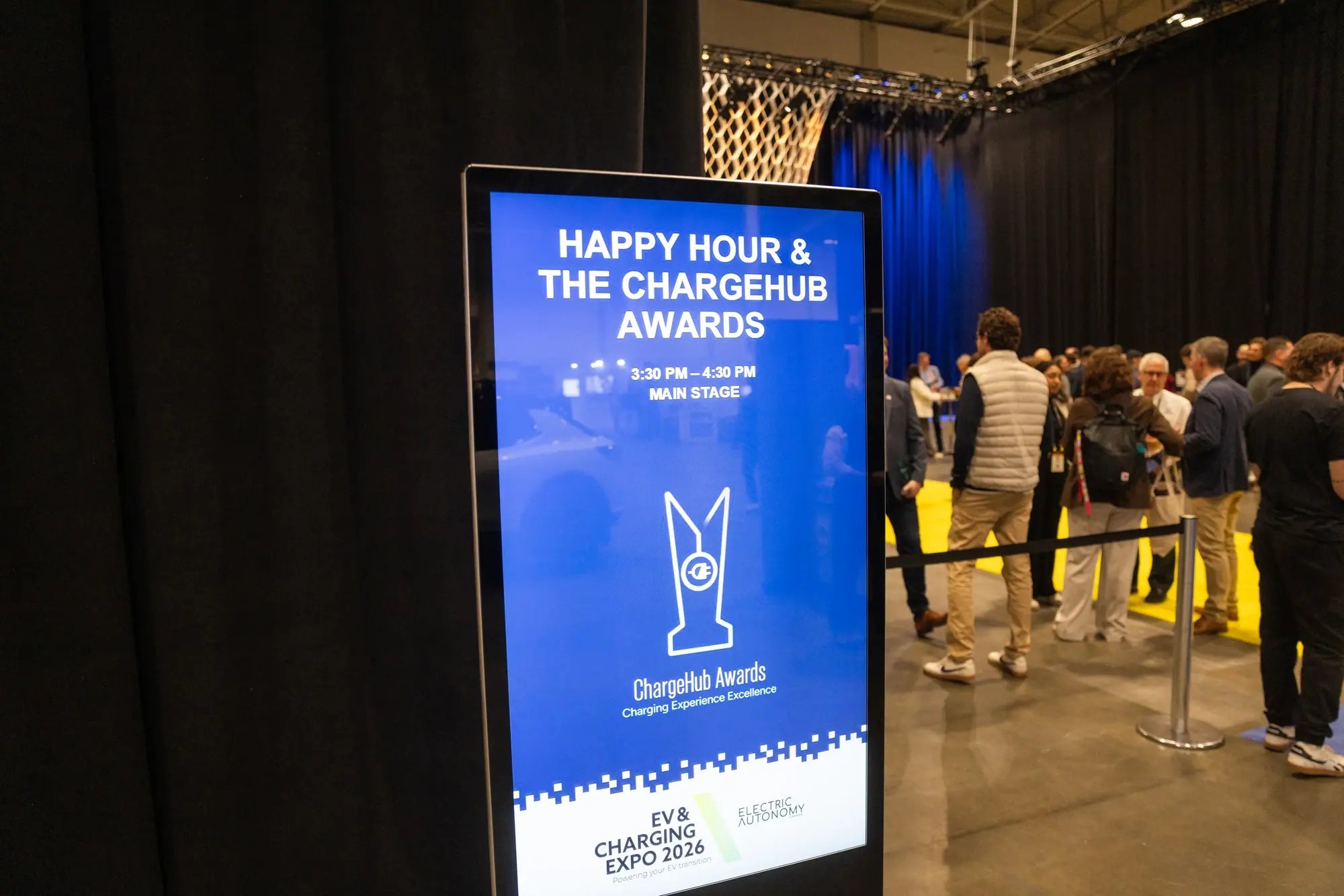 Event sign for Happy Hour and the ChargeHub Awards near the main stage.
