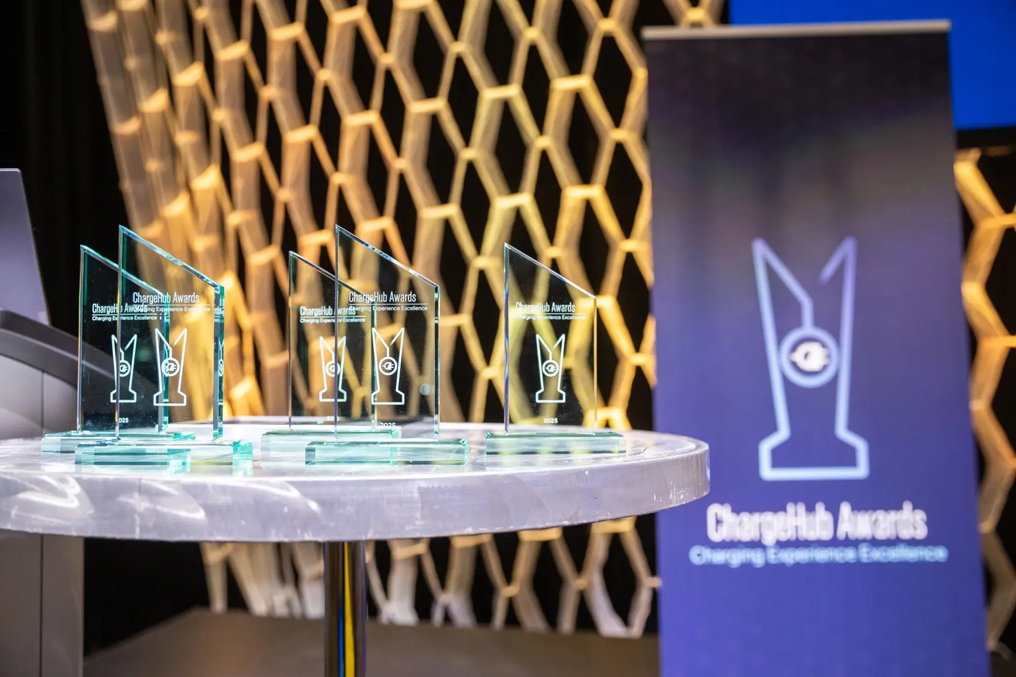 ChargeHub Awards trophies on display beside the event banner on stage.