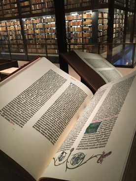 A rare Gutenberg Bible on display at the Beinecke Rare Book & Manuscript Library, opened to reveal its printed pages.