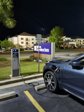Voiture électrique en recharge sur une borne rapide devant un hôtel aux états unis, lors d'un trajet du Québec vers la Floride.