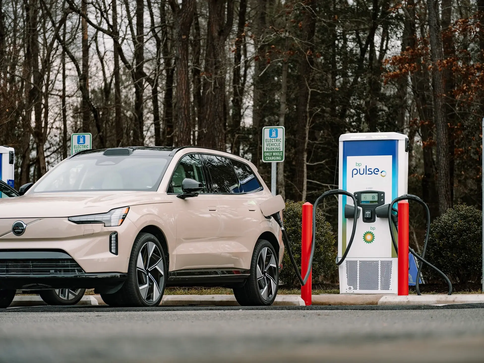 Electric SUV plugged into a bp pulse fast charger in a highway parking lot