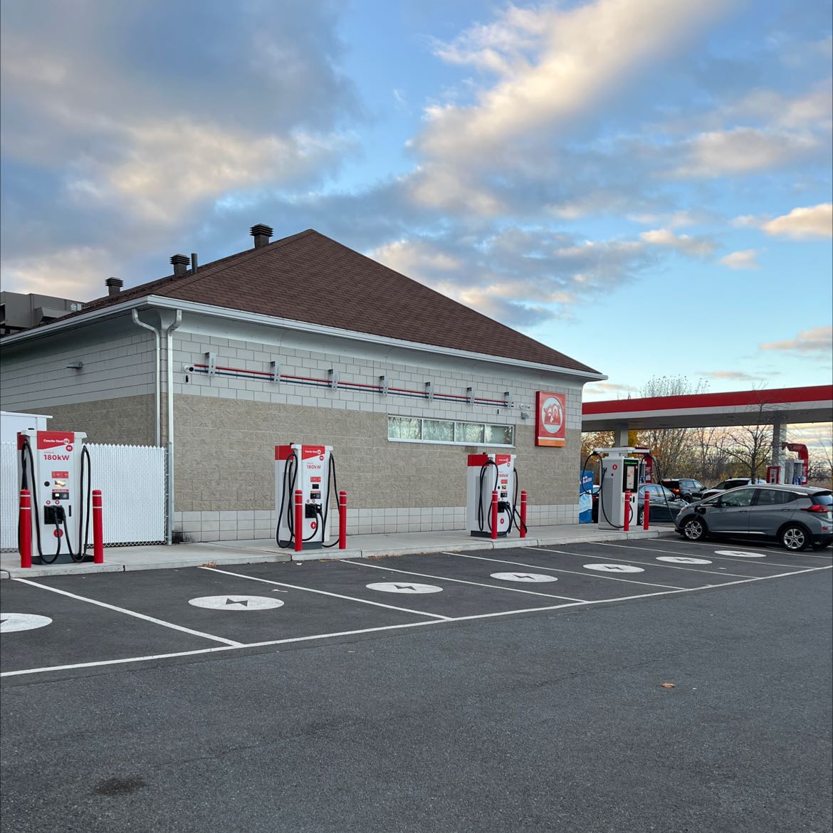 180 kW Couche-Tard/Circle K fast-charging stations outside a convenience store, illustrating the EV roaming network.
